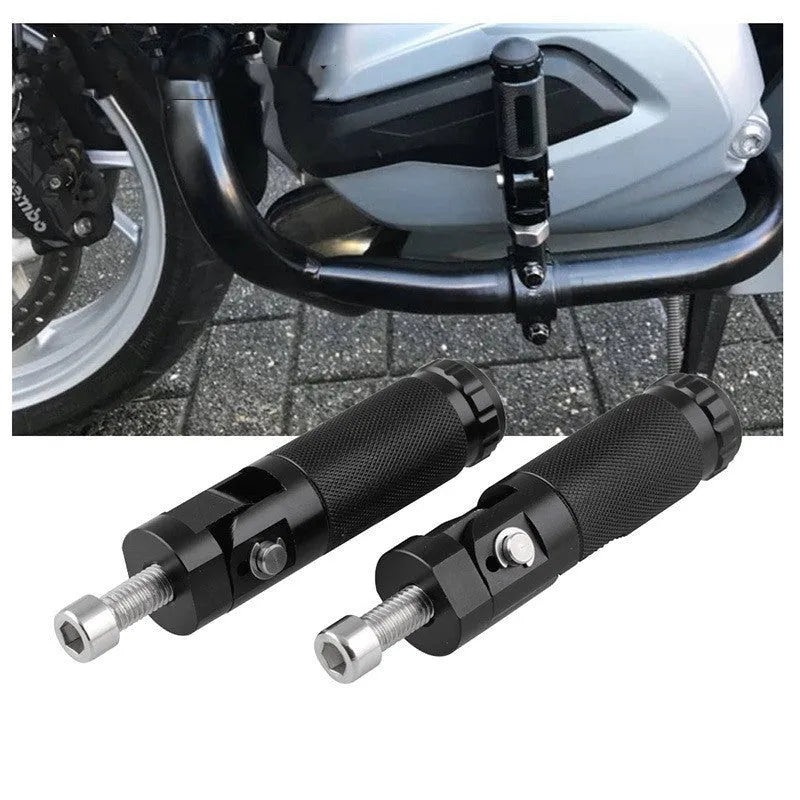 Two black aluminium alloy round folding motorcycle foot pedals on a workbench