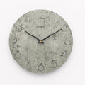 Modern grey European-style wall clock with a round face on a white wall.