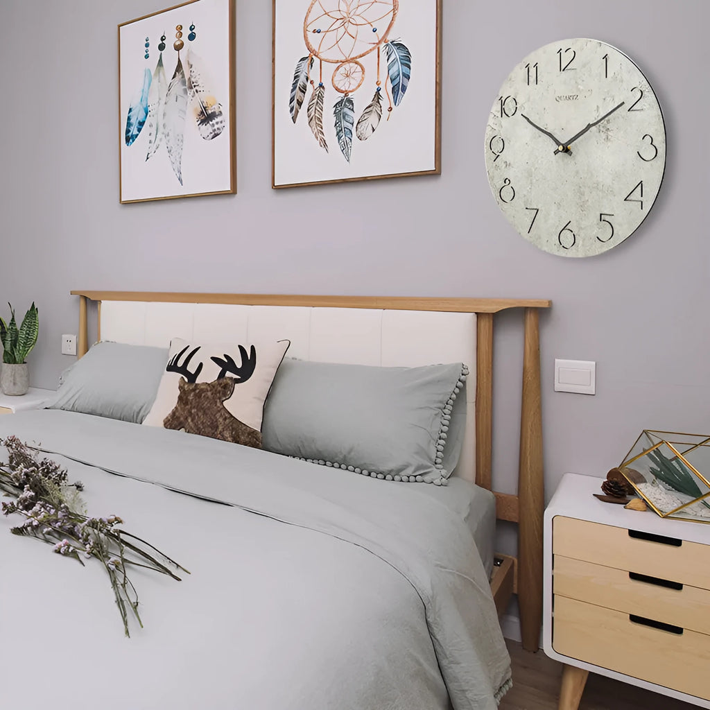 Modern grey European-style wall clock with a round face on a white wall.