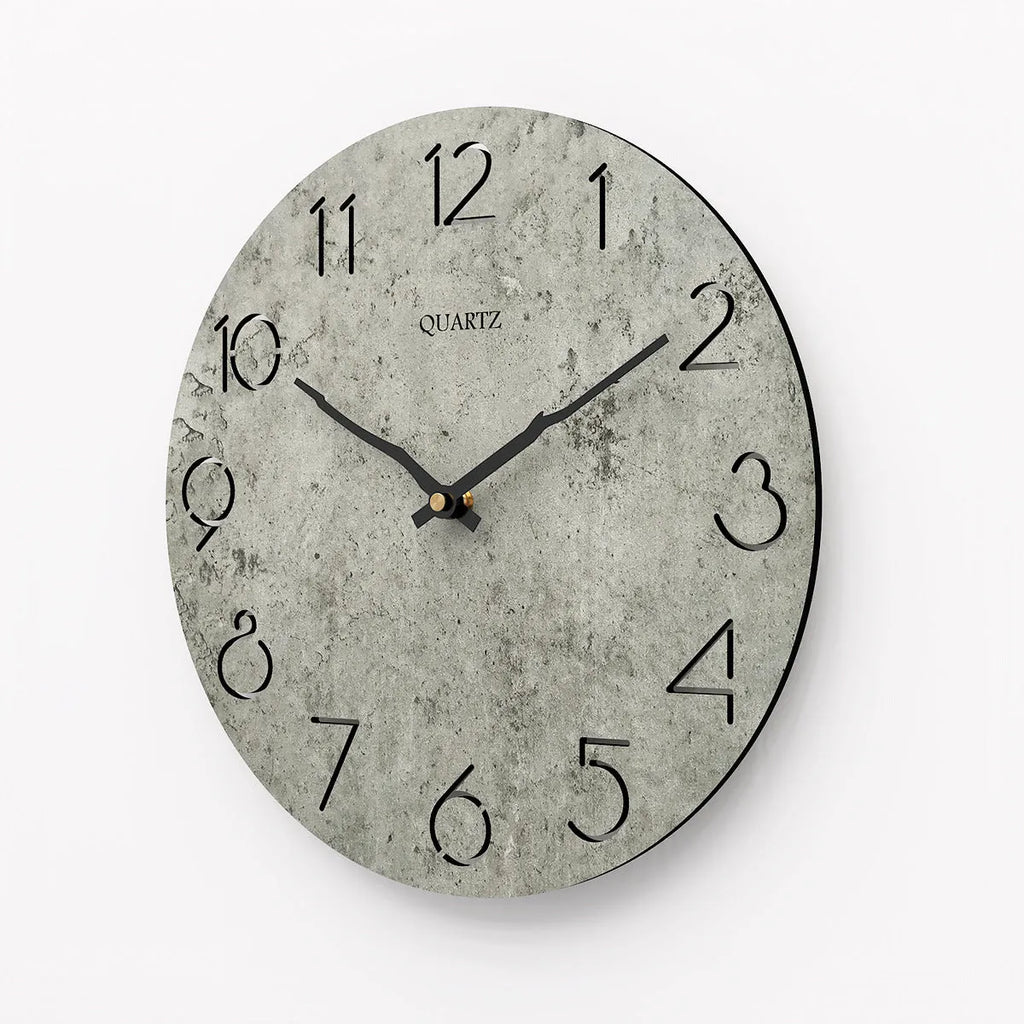 Modern grey European-style wall clock with a round face on a white wall.