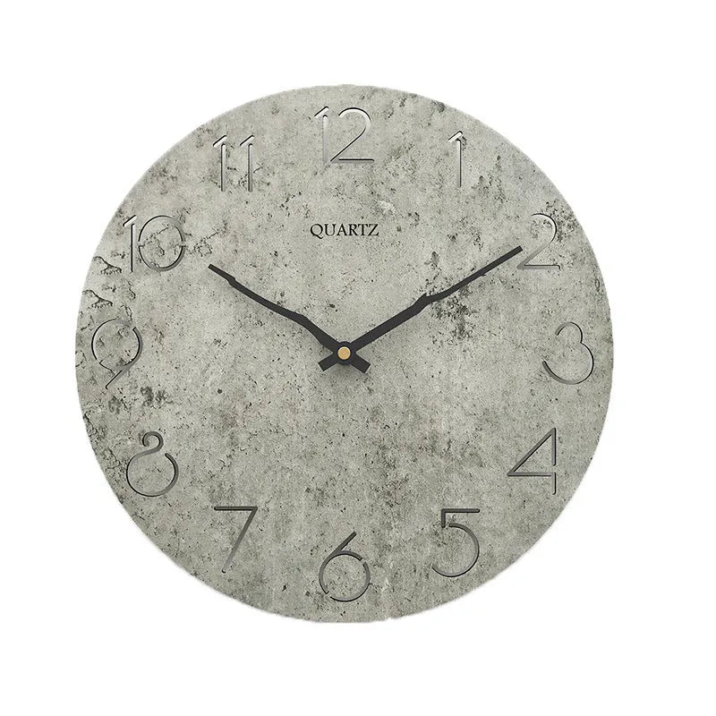 Modern grey European-style wall clock with a round face on a white wall.