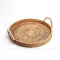Round handwoven rattan storage basket with a wooden handle on a table.