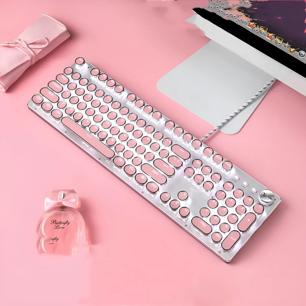 Queen Lipstick mechanical keyboard with green switches, white backlight, silver base, pink accents, and wired USB mouse on a desk.