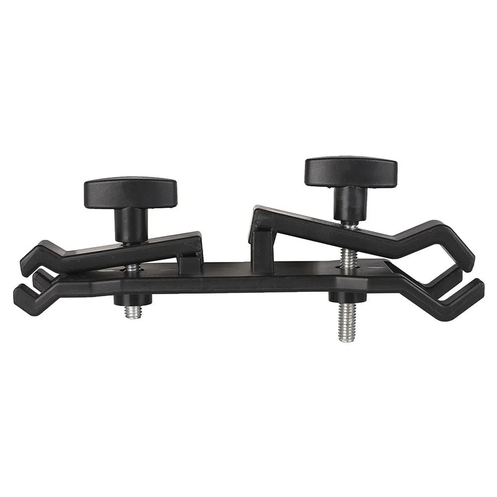 Black plastic umbrella clip attached to a tripod leg, holding a folded umbrella.