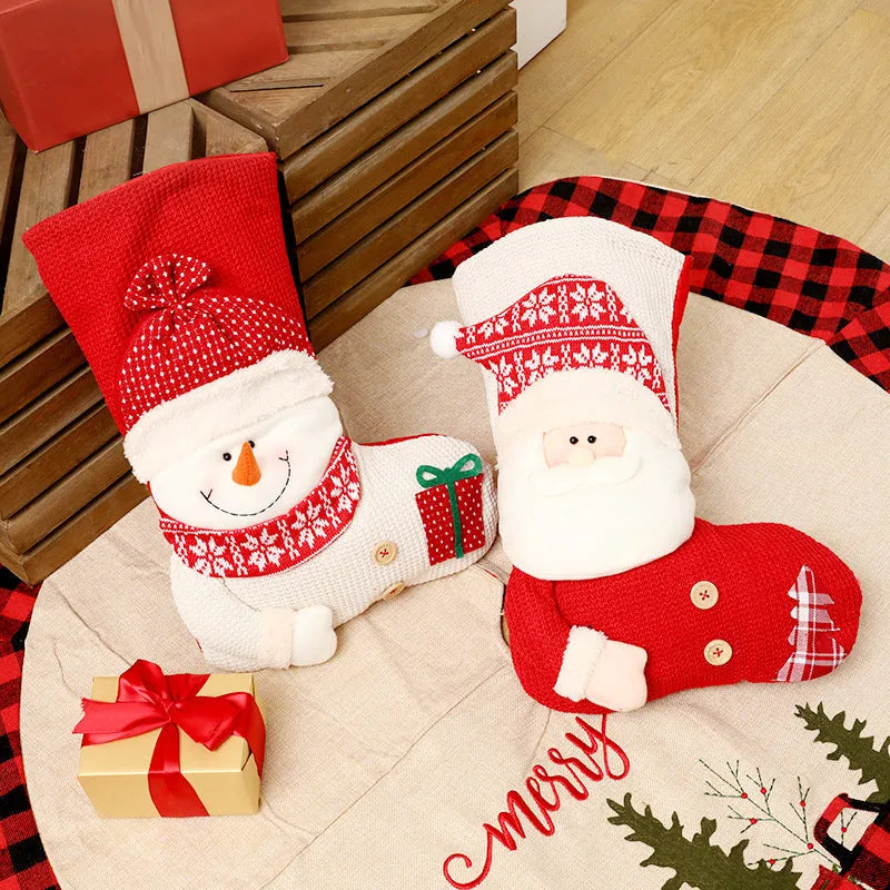Large red and white knitted Christmas stocking with Santa Claus or Snowman design on a fireplace mantel