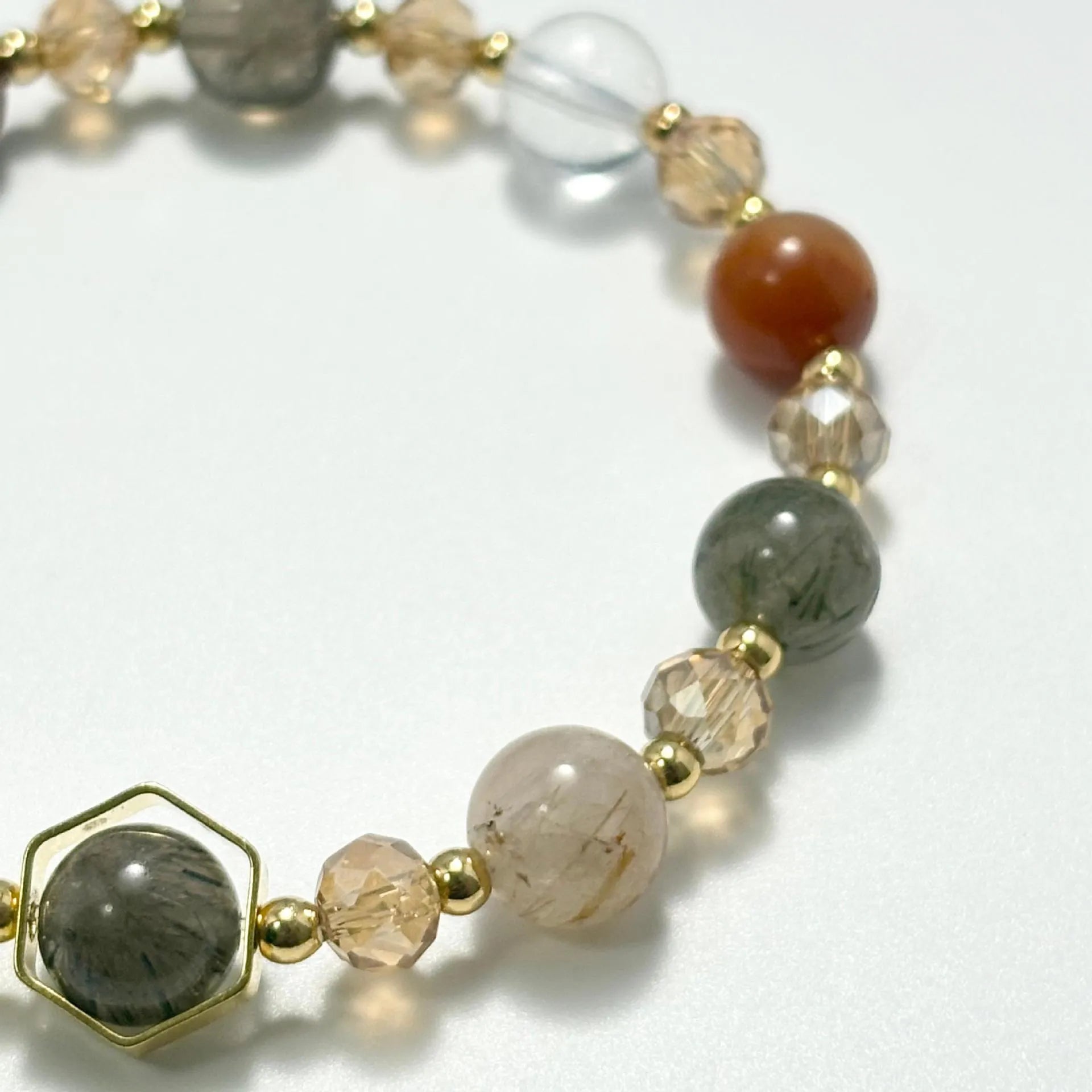 Gold citrine crystal bracelet with Fu character, safety lock, and cloud pattern charms on wrist