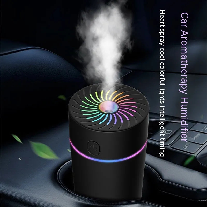 A small white or black USB car humidifier with aromatherapy function on a car dashboard.