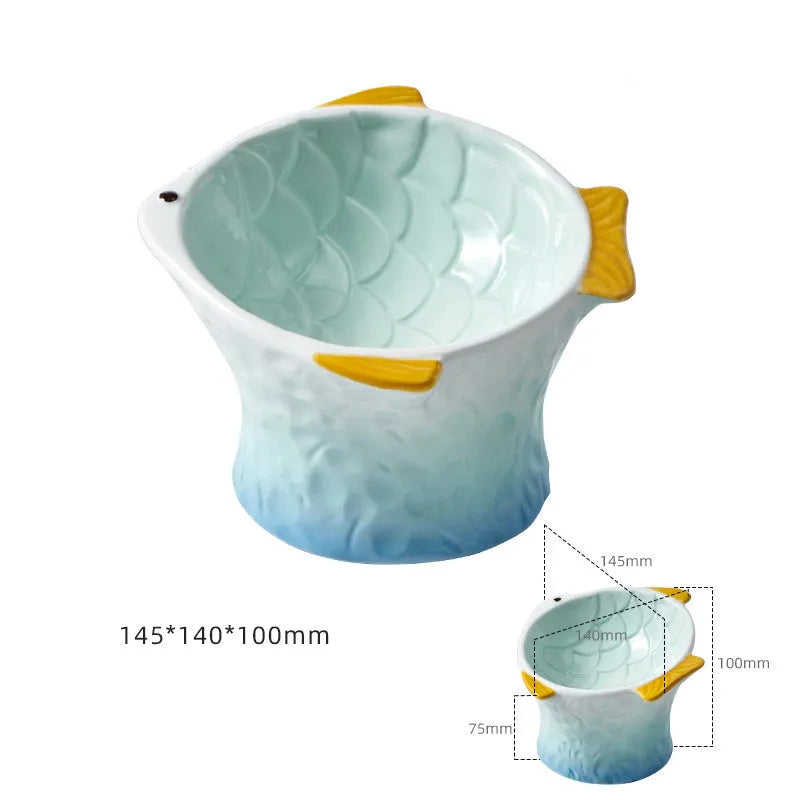 Blue ceramic fish-shaped cat bowl with tilted design and non-slip base on a wooden surface