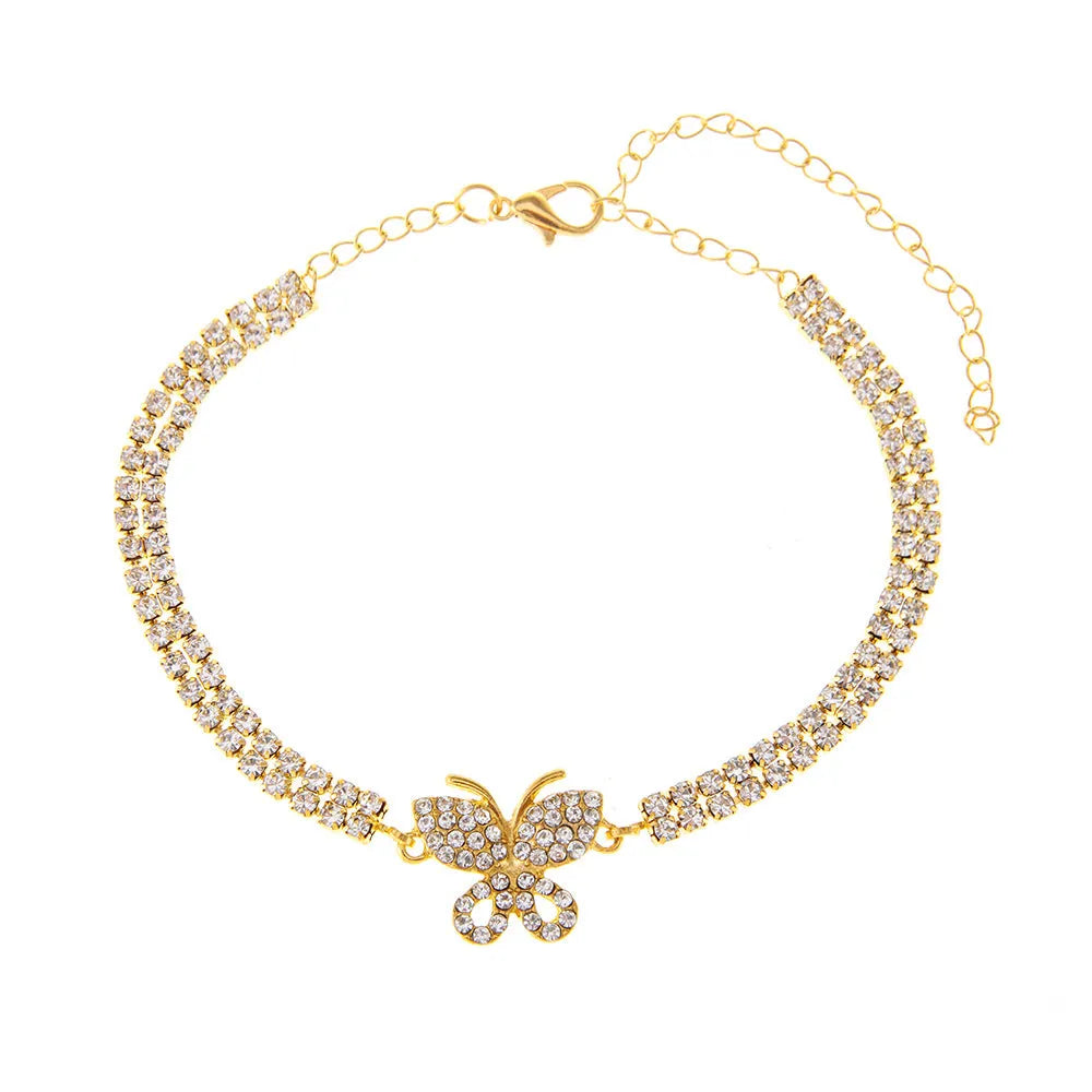 Gold rhinestone butterfly anklet with bow shape and gemstone inlay on white background