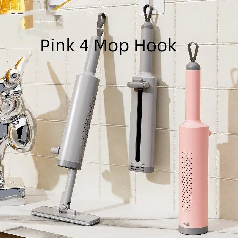 Pink self-squeezing rotatable mini flat mop with microfiber pad on a hardwood floor.
