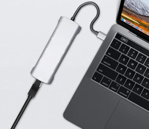 Grey aluminium USB-C docking station with multiple ports including HDMI, VGA, and USB, showing its 140mm attached cable.