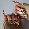 Leopard print pattern on a 3D plastic butterfly nail art charm for manicure decoration.