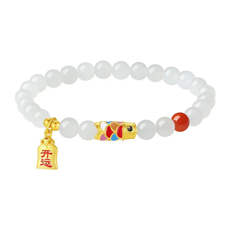 Close-up of a sterling silver bracelet with a carved green Hetian jade koi fish charm.