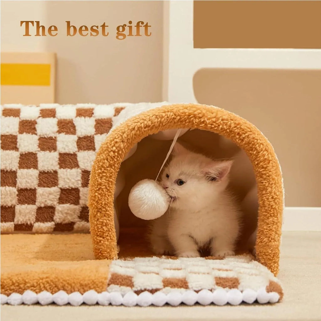 Brown plush plaid cat tunnel bed with a central mat, shown on a wooden floor.