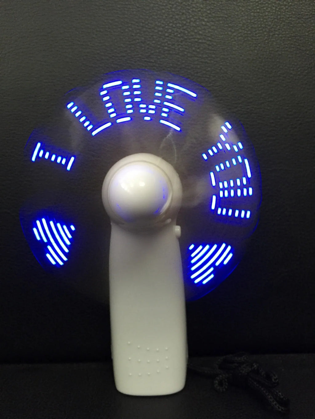 White handheld mini fan showing blue LED 'I Love You' pattern, dimensions 10.8cm.