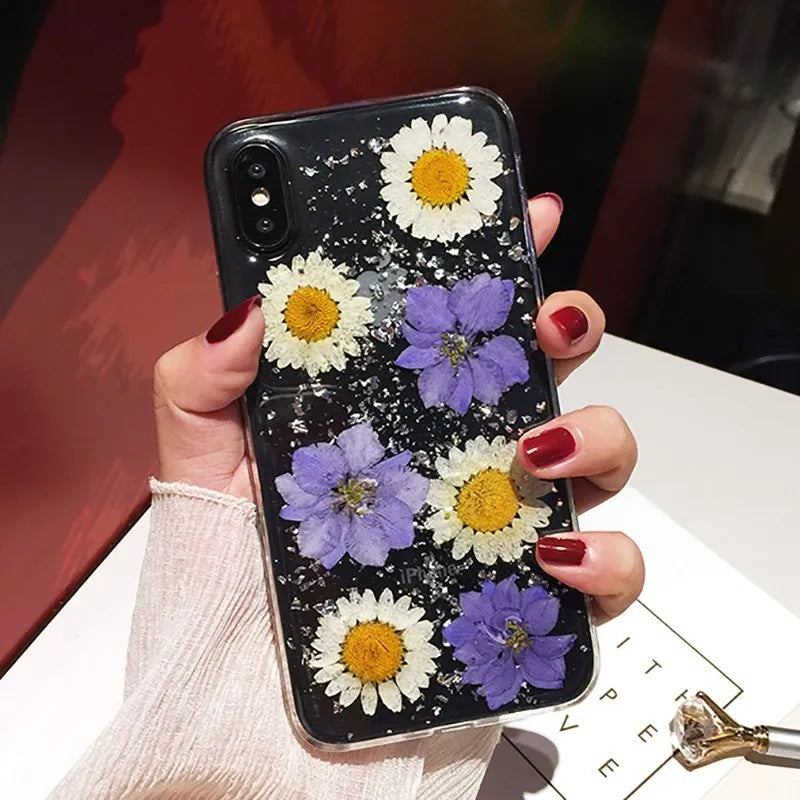 Clear iPhone case with real pink dried flowers preserved under glossy epoxy resin.
