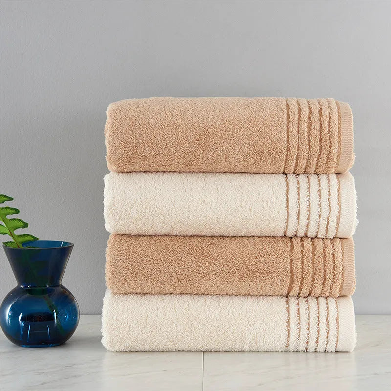 Beige and brown cotton towel set showing bath towel, hand towel, and face cloth sizes