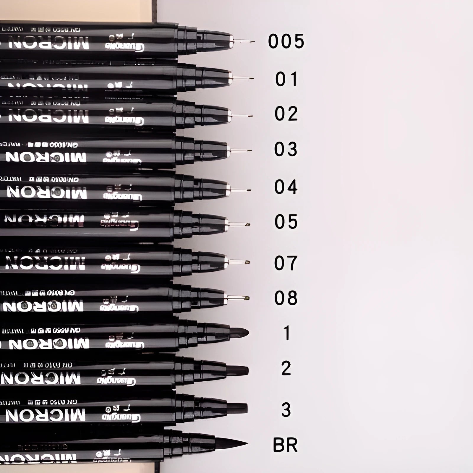 Set of 12 black comic drawing pens with assorted microtip nibs in a fabric organiser pouch.