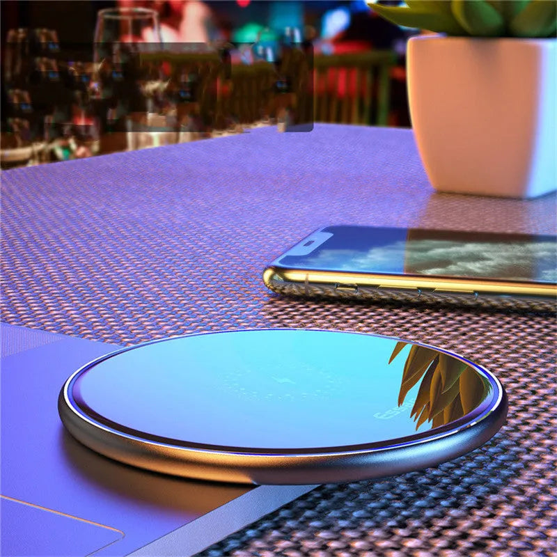 Black aluminium alloy 15W Qi wireless charging pad on a table with LED light.