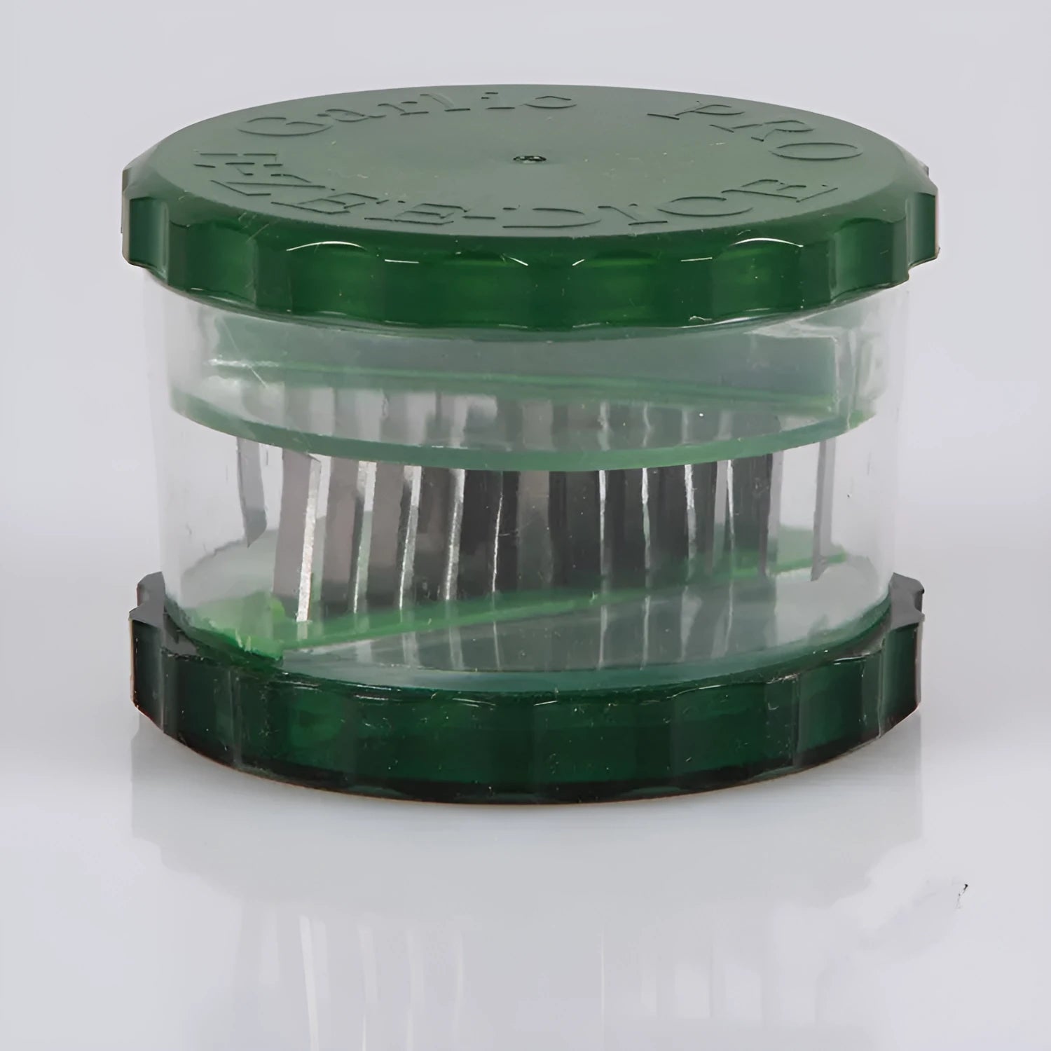 Green transparent plastic garlic peeler kitchen gadget on a counter.