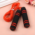 Adjustable jump rope with weighted black handles on a gym mat