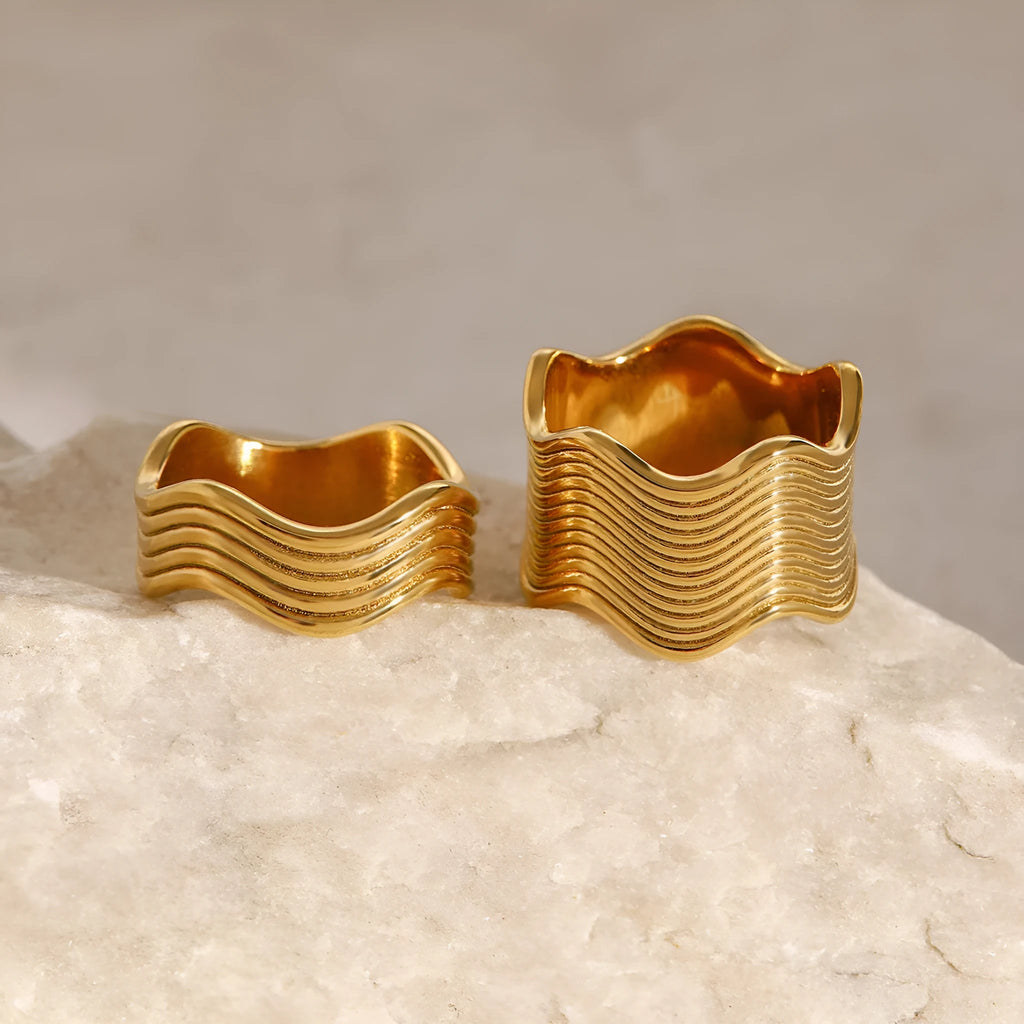 Stainless steel geometric wave ring with wide band and electroplated finish.