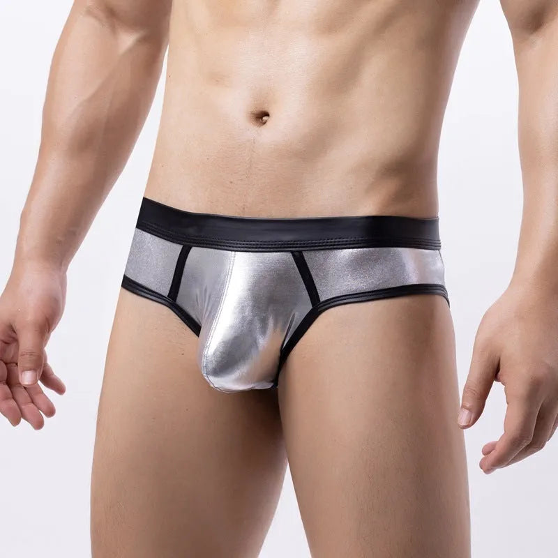 Man wearing low-waist gold bikini swim briefs on beach