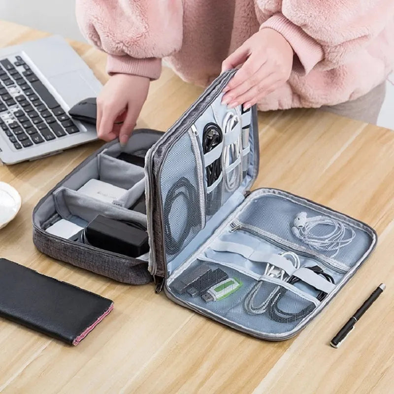 Grey waterproof electronics organiser bag with double-layer interior, handle, and zipper closure