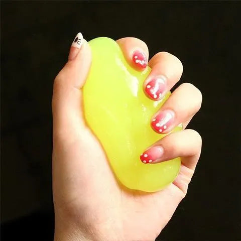 Blue and yellow lumps of Magic Cleaning Gel adhesive putty for dust removal, shown with a car vent and keyboard.