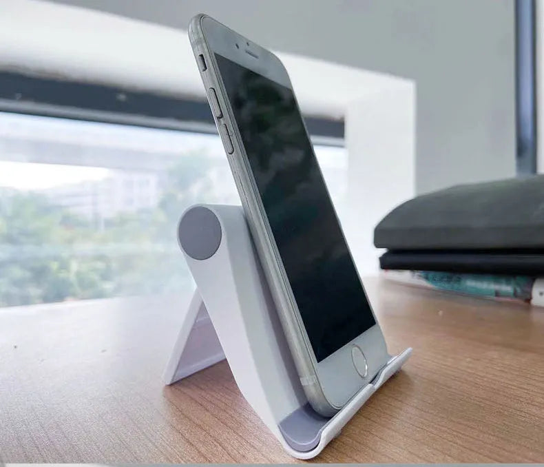 Black folding PE plastic mobile phone and tablet stand holding a smartphone at an angle.