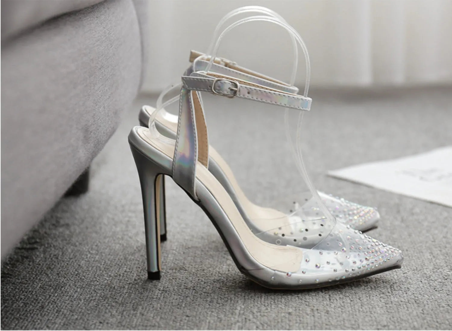Women's pointed-toe PVC sandals with a stiletto heel on a plain background.