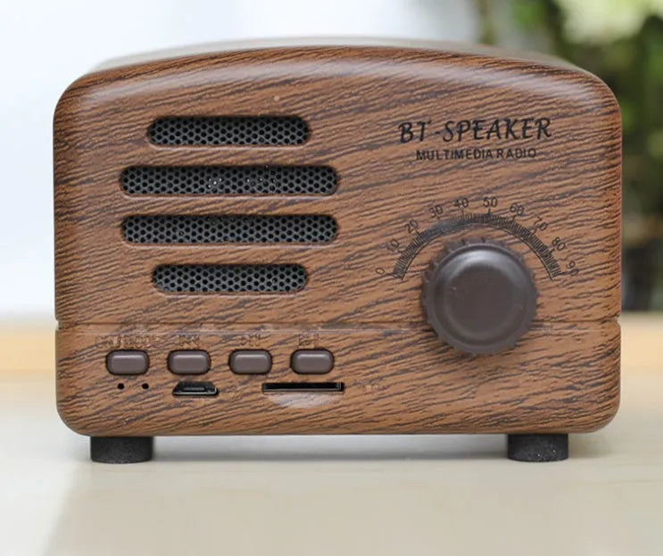Vintage-style wooden Bluetooth speaker in wood grain finish showing front grille and compact size.