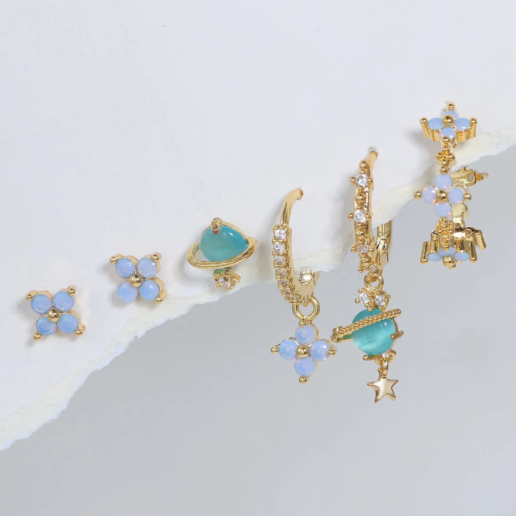 Gold and silver Japanese Korean style ear studs with blue flower nail design and zircon detail