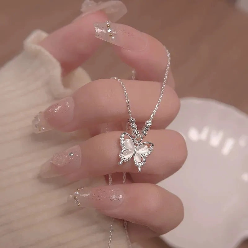 Women's silver butterfly necklace with opal pendant on a cross chain, showing adjustable length.