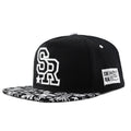 SR Black cotton baseball cap with front letter embroidery, showing adjustable snapback strap and dome crown.