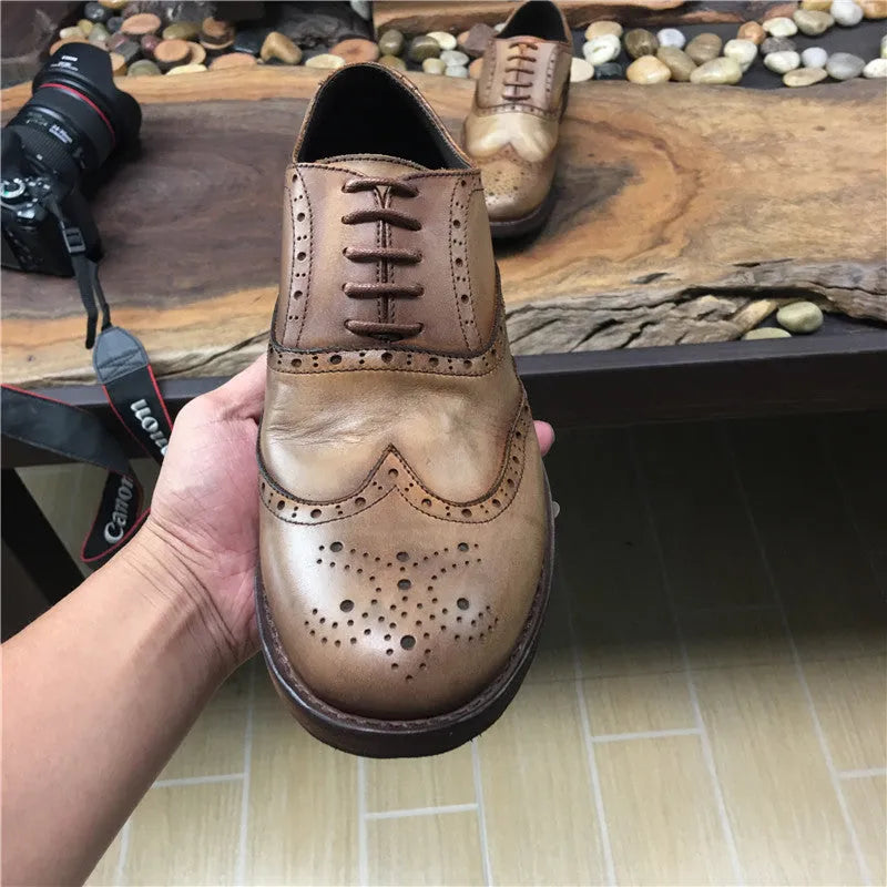 Light brown men's distressed leather lace-up shoes with engraved detailing and round toe on a neutral background.