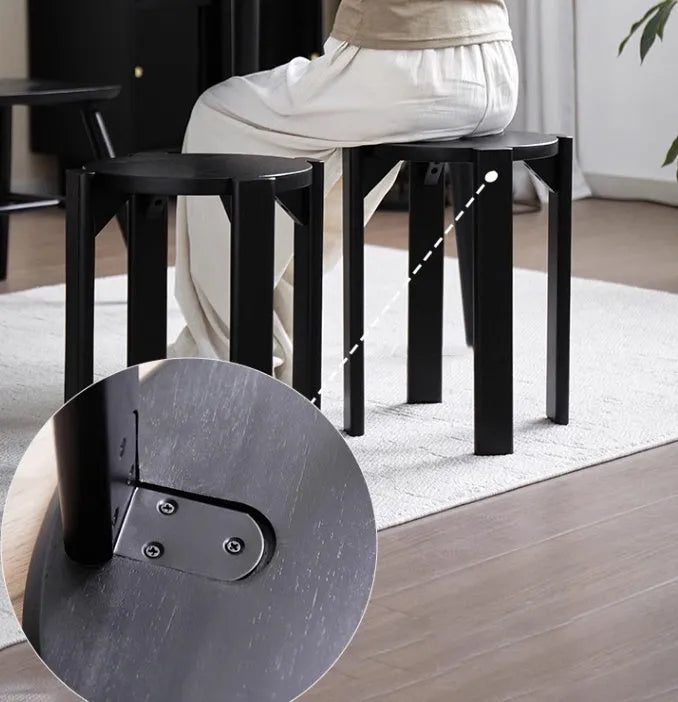 Set of four stackable iron dining stools with circular seats in a modern design, shown nested together.