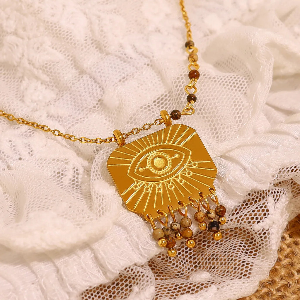 Retro gold titanium steel chain necklace with square natural stone pendant and evil eye motif on white background