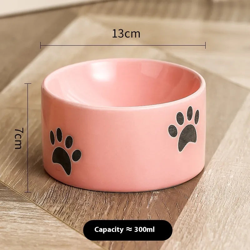 Ceramic cat food bowl with high foot base in a cat's paw print design
