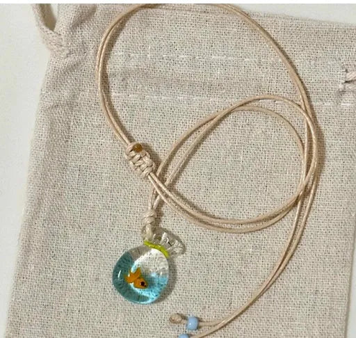 Women's joker motif pendant necklace on a braided cotton and linen clavicle chain.