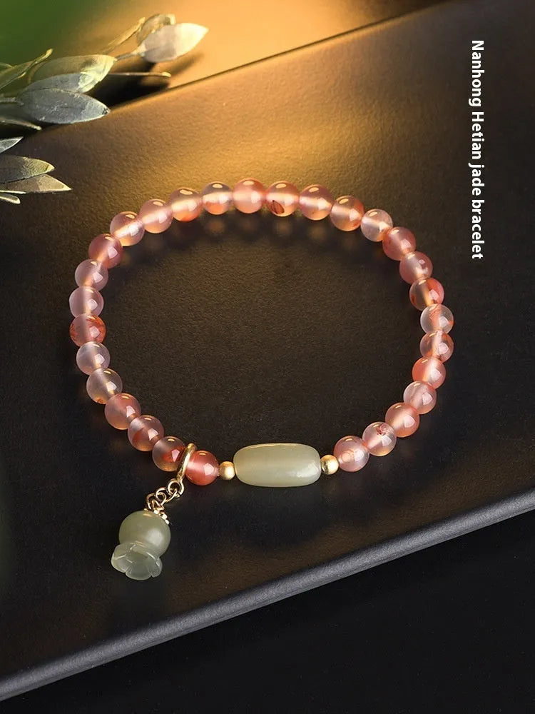 Polished Nanhong Agate flower bracelet with bamboo joint design on wrist.