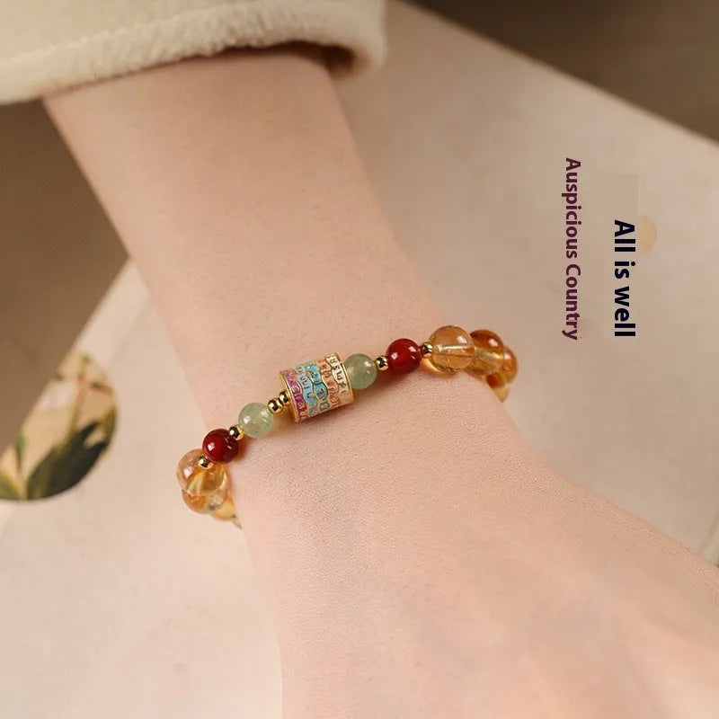 Yellow citrine prayer wheel bracelet with 8mm round beads on wrist