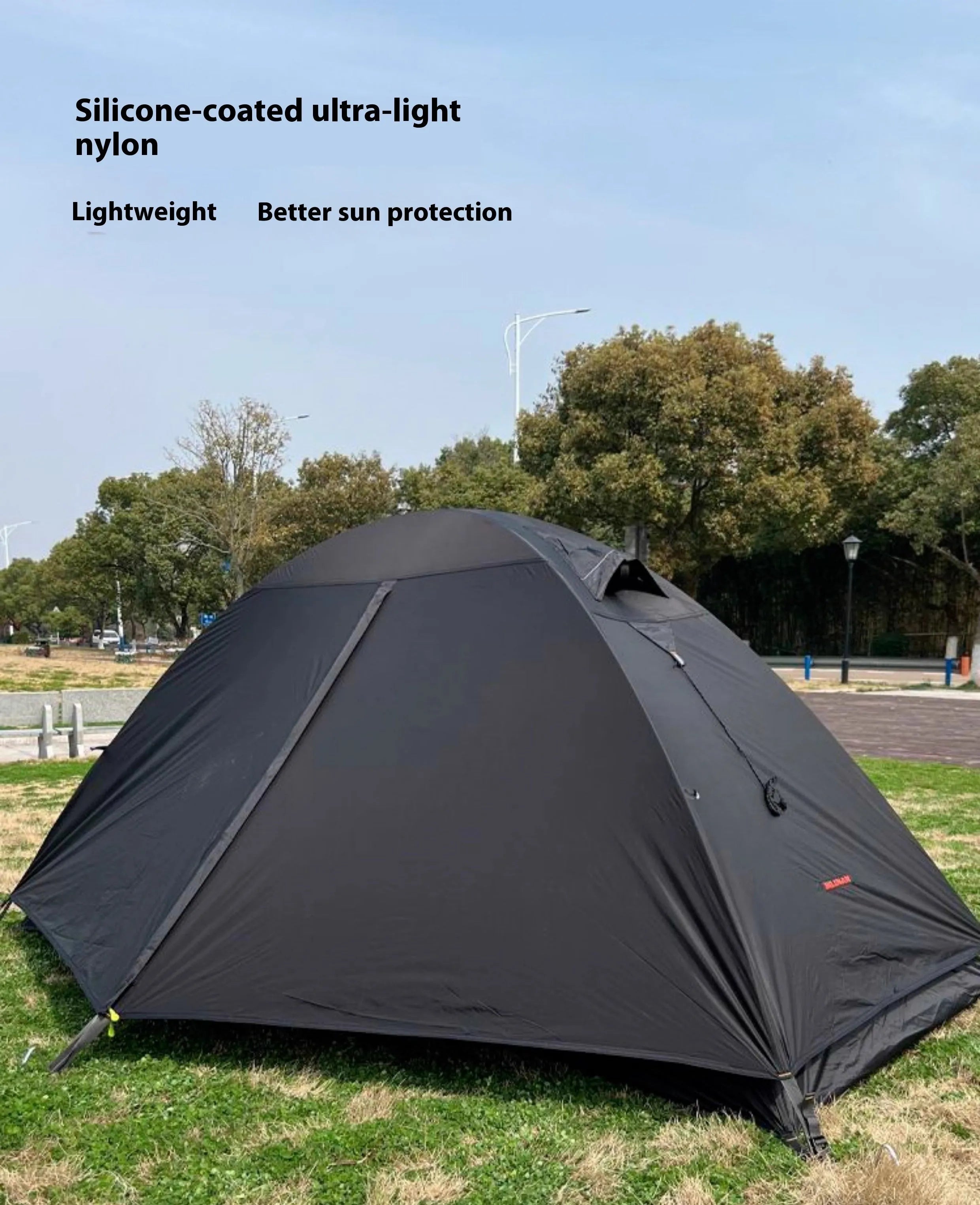 Single person green tunnel tent with aluminium poles pitched in a forest, showing mesh door and waterproof flysheet.