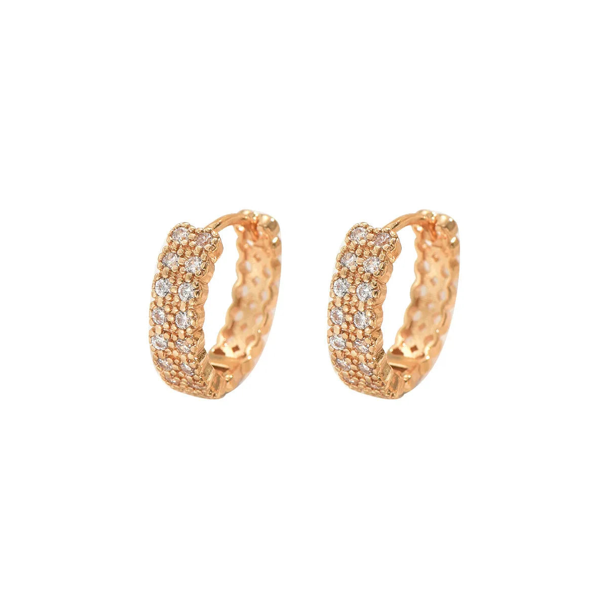 Close-up of women's copper geometric ear studs showing dot and ring pattern on a stud fitting.