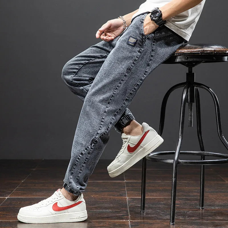 A pair of men's loose-fit cargo jeans in a blue colour, showing the straight leg and casual style.