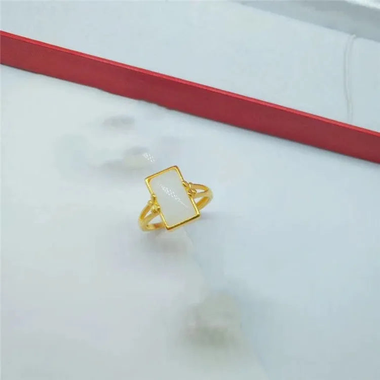 Adjustable brass gold-plated ring with a green gemstone inlay, showing national style design