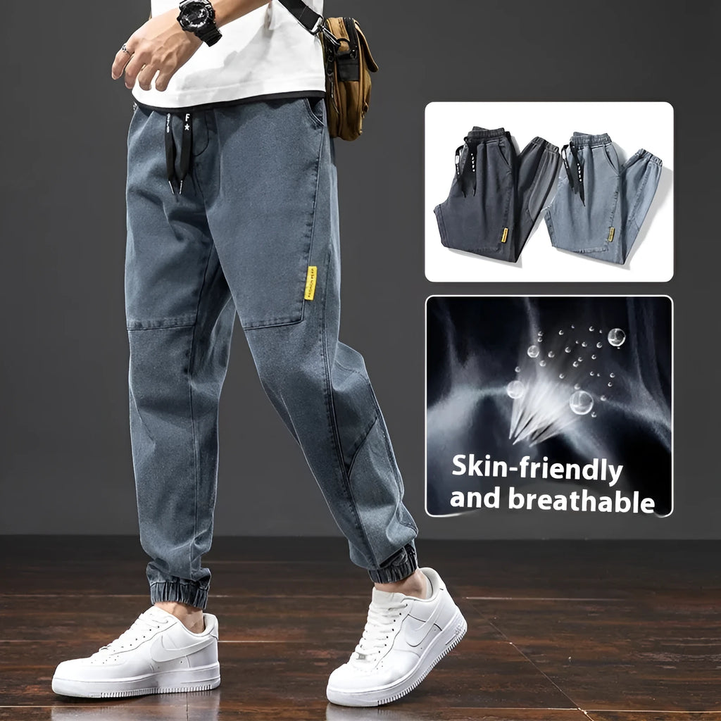 A pair of men's loose-fit cargo jeans in a blue colour, showing the straight leg and casual style.