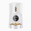 Black and white automatic pet feeder with digital timer and USB cable for remote, portion-controlled feeding.