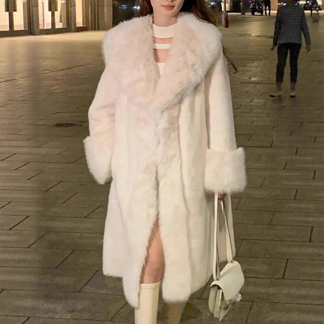 A grey women's mid-length faux fur and leather coat with a fur collar on a hanger.