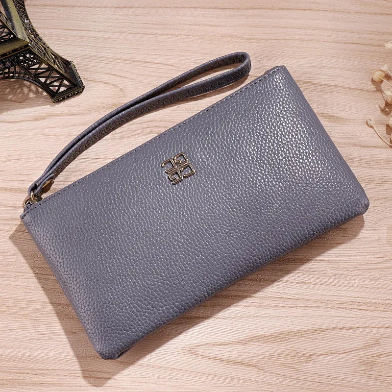 Long black PU leather zip wallet handbag open, showing phone slot and card organisers inside.